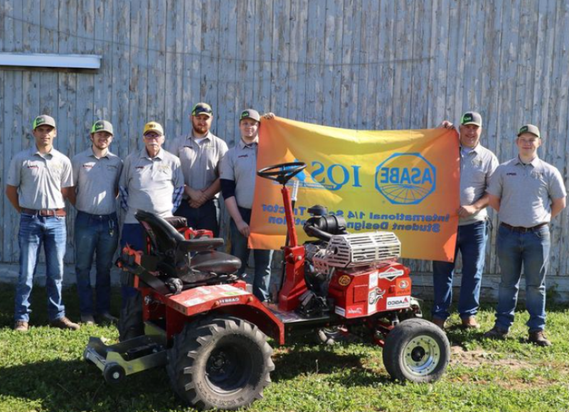 students pose with a tractor they built