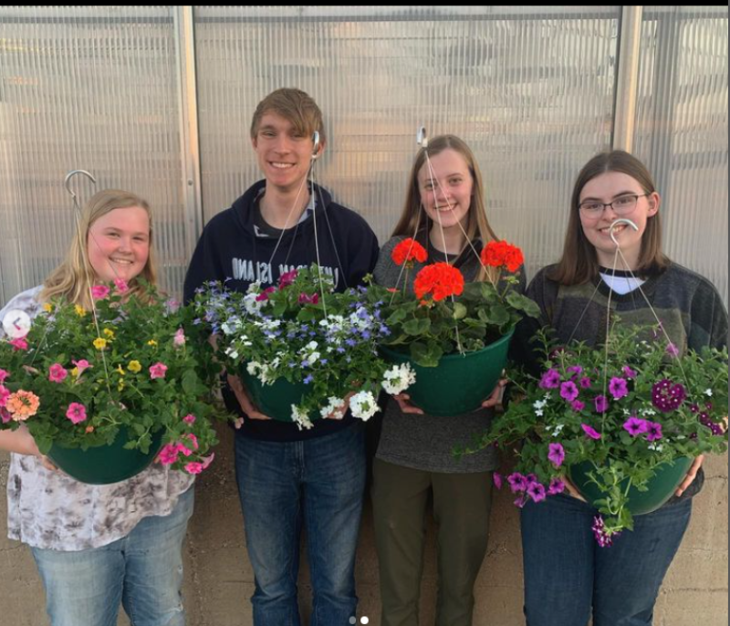 students pose with planters they created